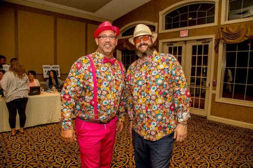 Two men in matching bright floral shirts